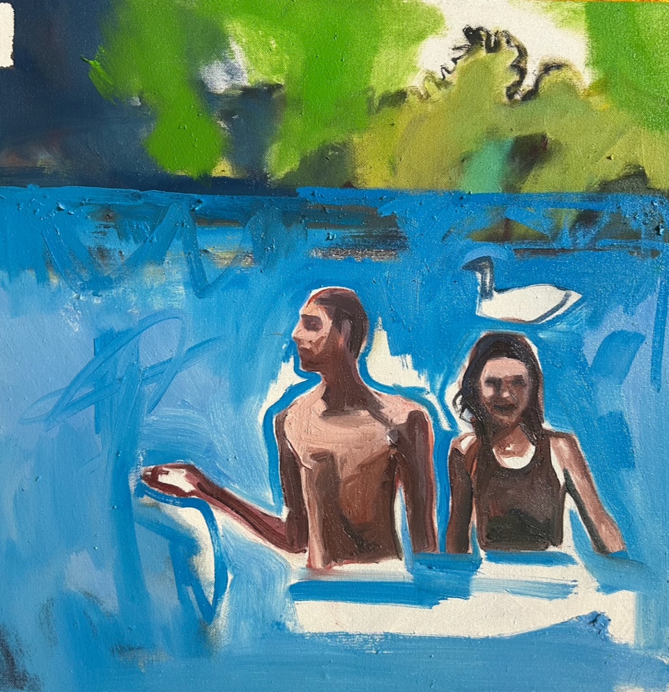 Two swimmers in blue water below a green shoreline